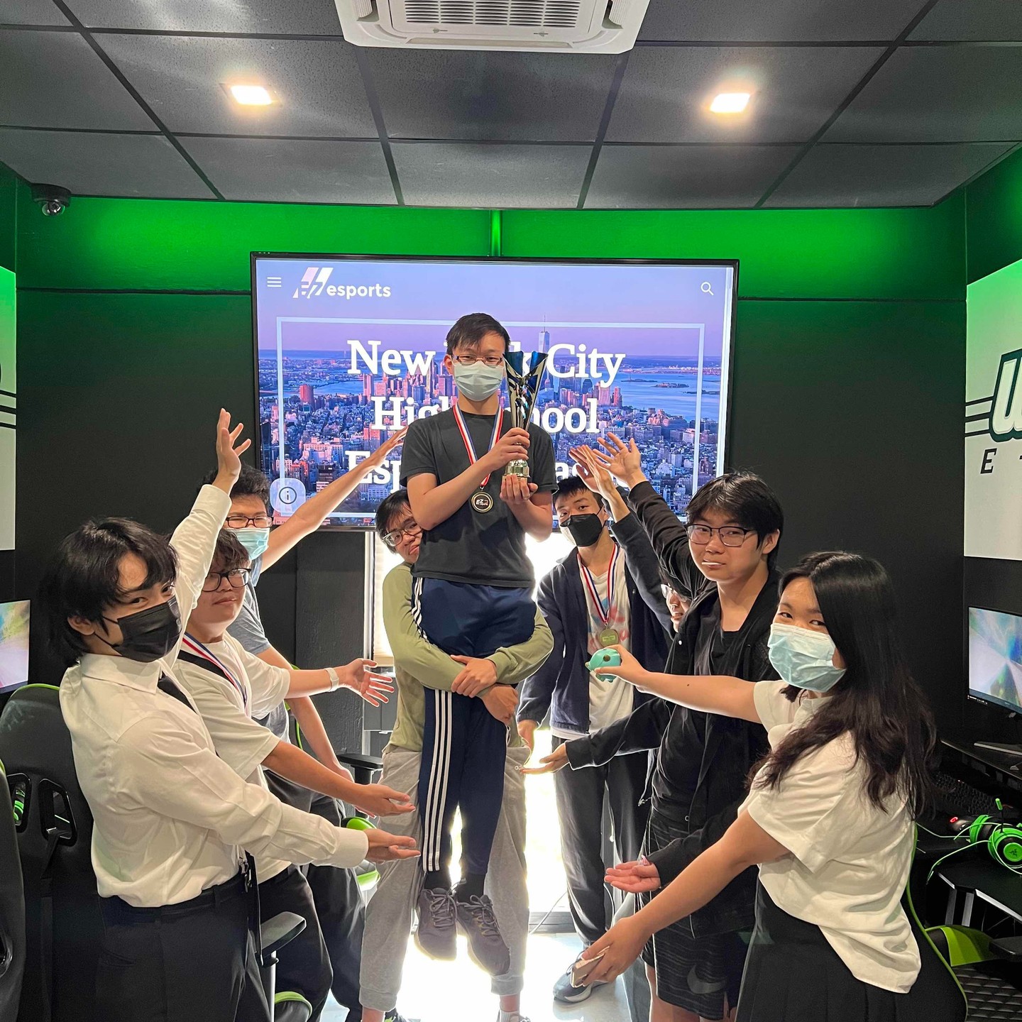A winner lifted up and celebrated by teammates in the Wagner College esports lounge