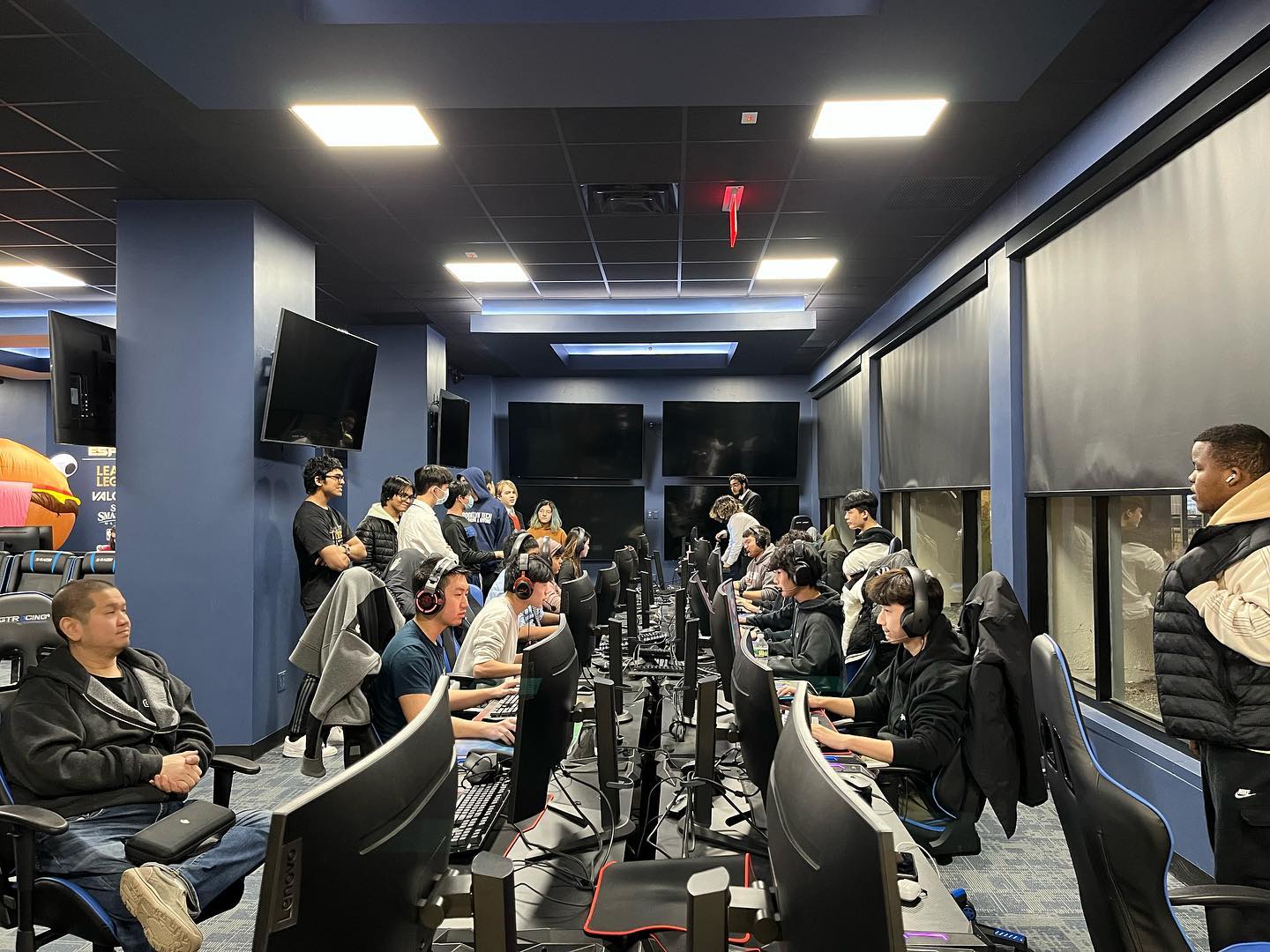 Wide shot of the packed LIU Esports Arena during match play.
