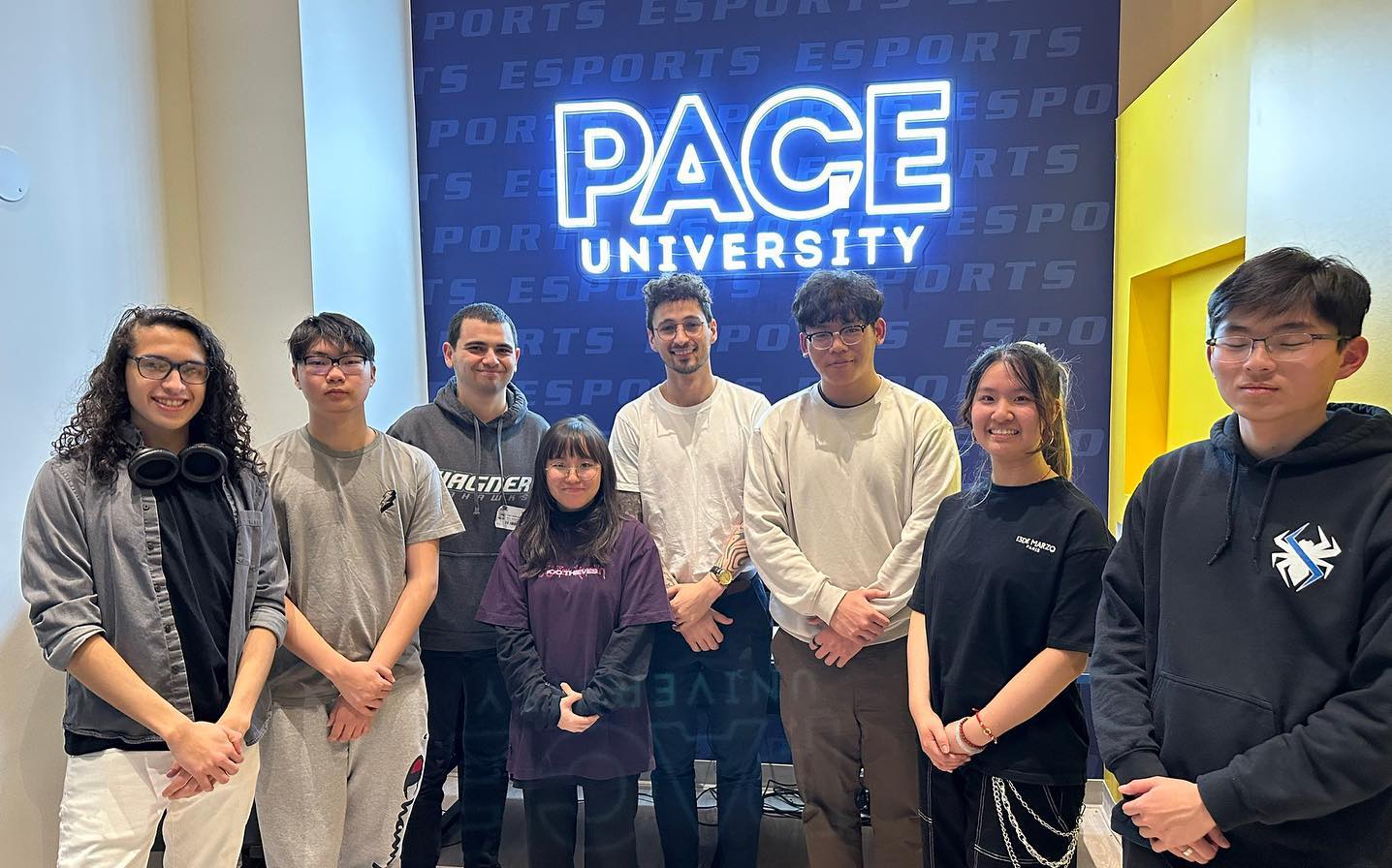 Players posing together in front of the "Pace University" sign
