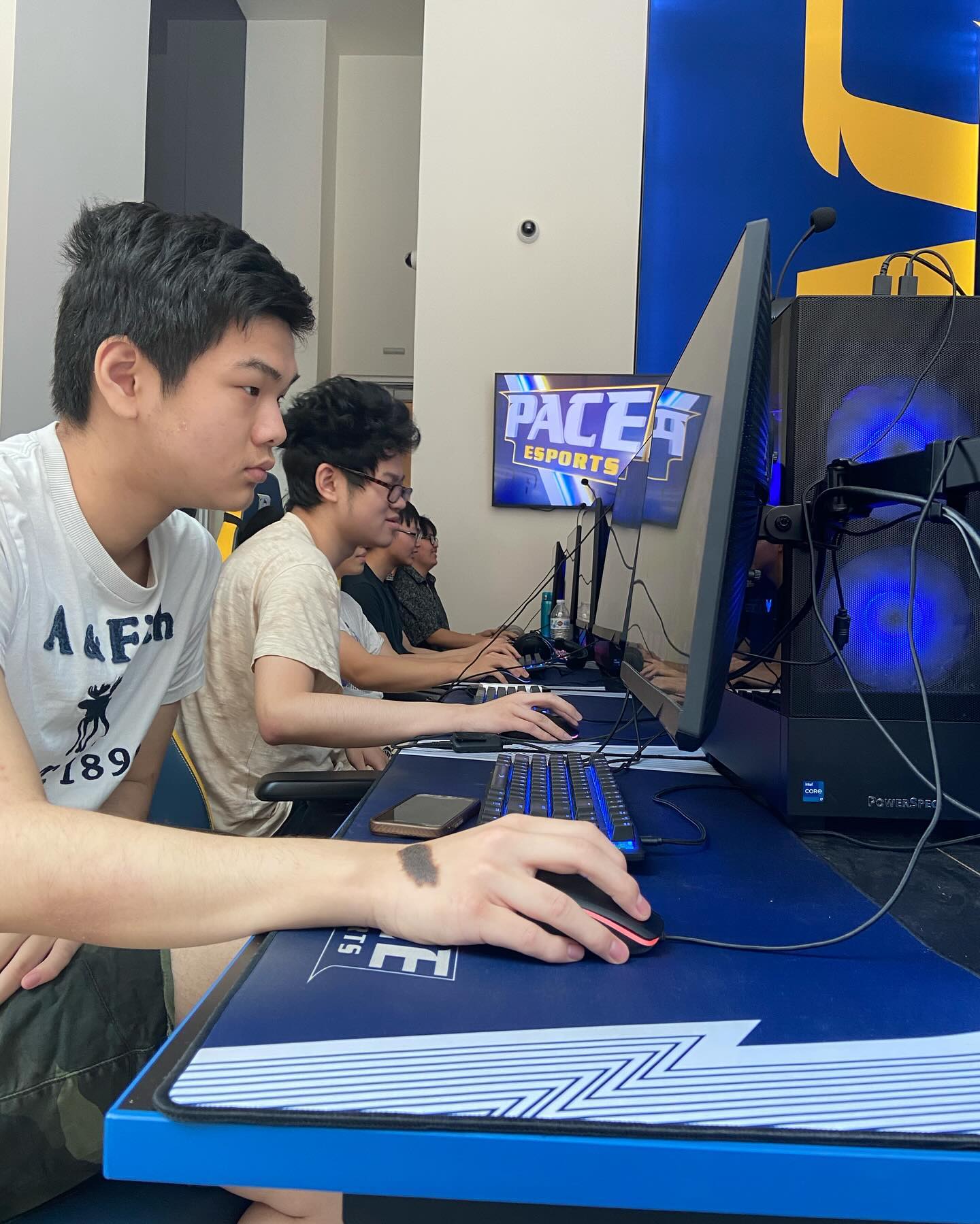 Close-up of players focused mid-game at the "PACE ESPORTS" esports arena