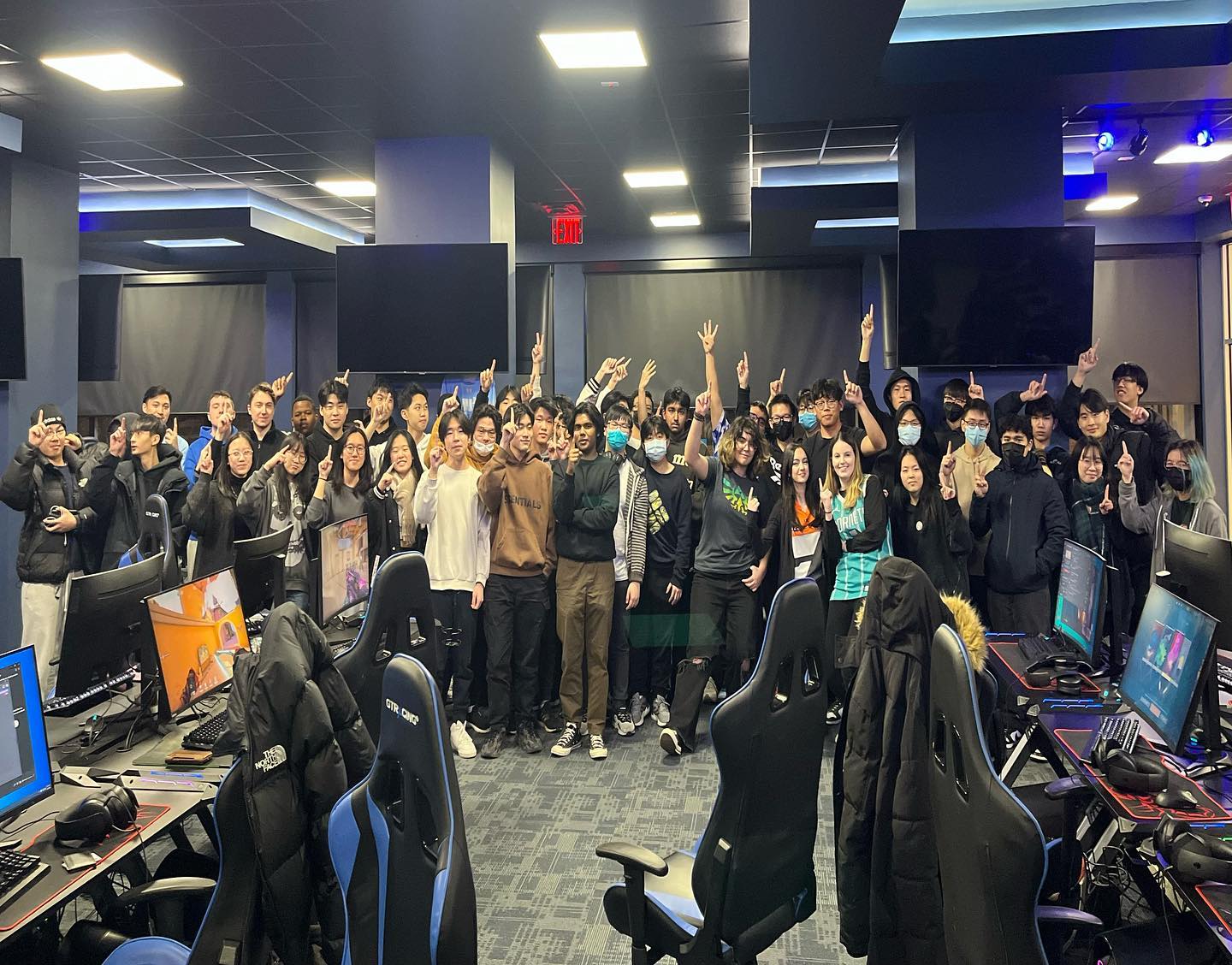 Big all-attendee group photo, everyone raising their hands together