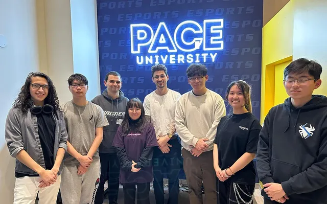 Players posing together in front of the "Pace University" sign